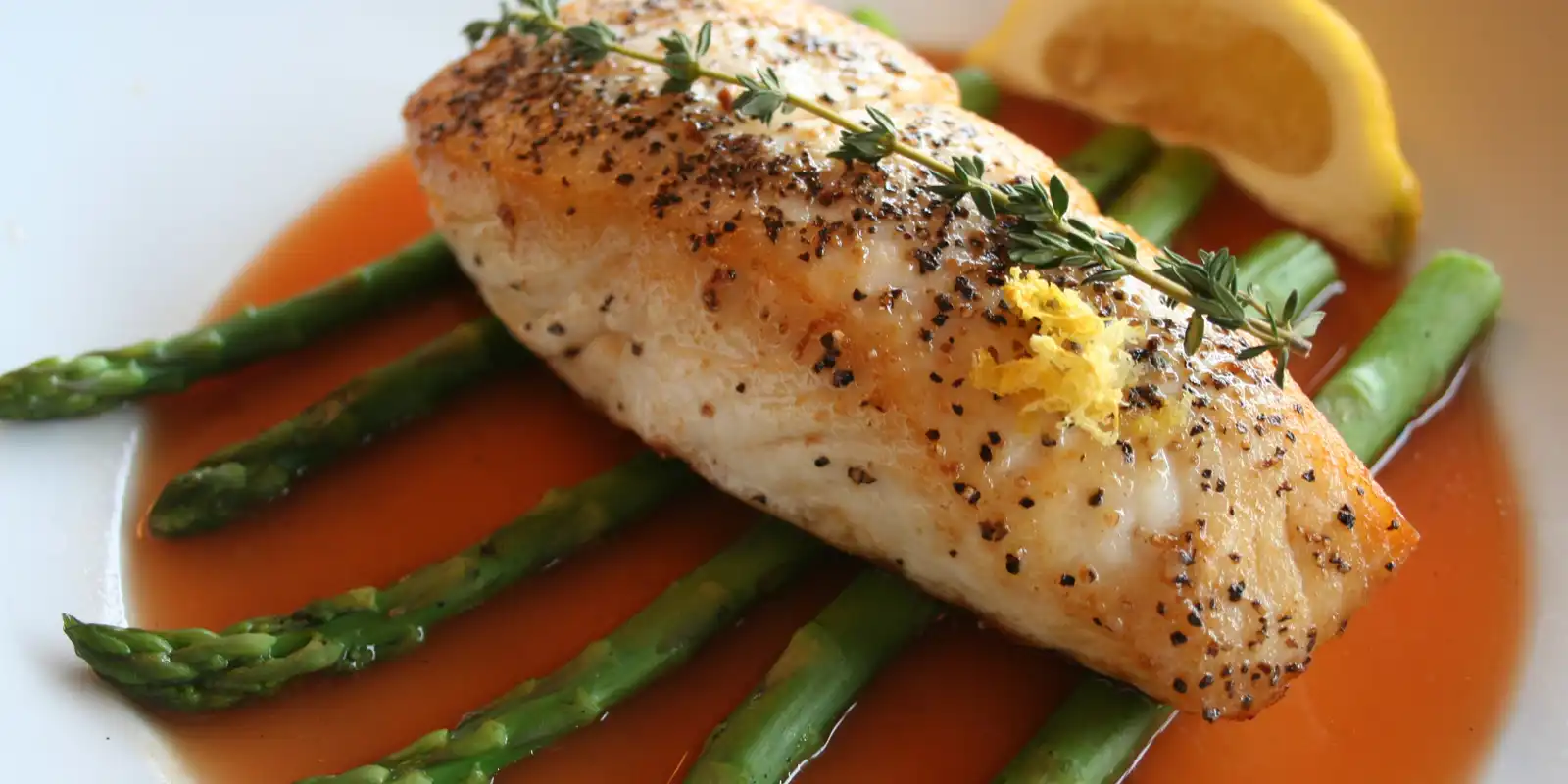 Pan seared halibut on raft of asparagus with poured sauce